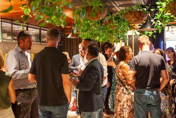 A group of people networking under green foliage